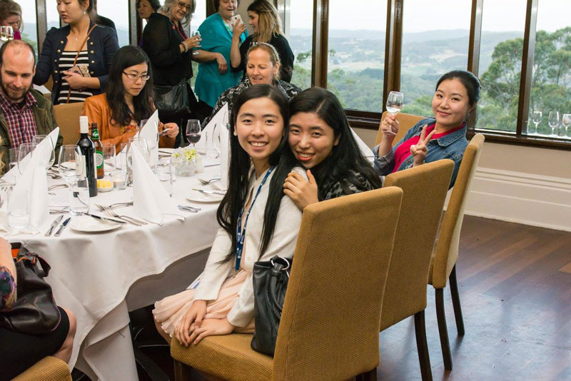 stp&a conference attendees smiling together in large banquet chairs at a nice dinner setting